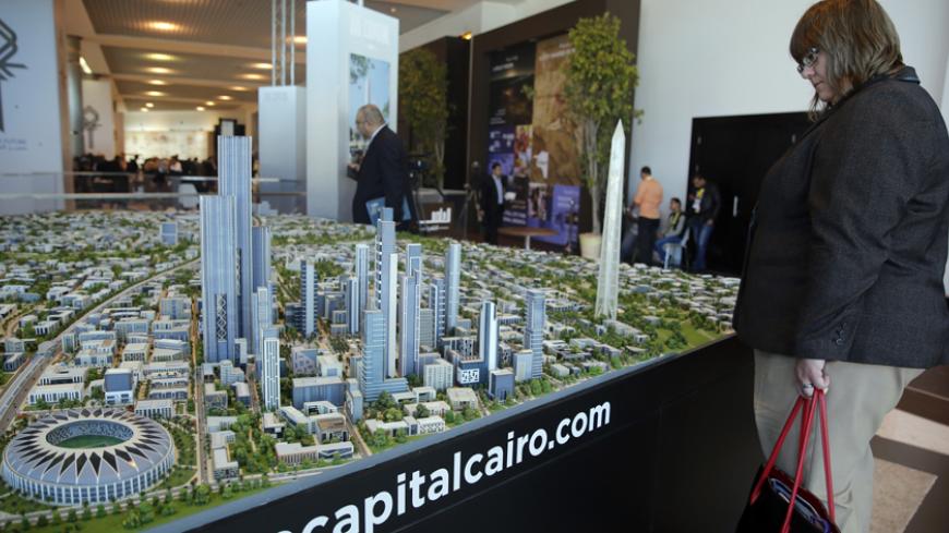 A delegate looks at a model of a planned new capital for Egypt during the final day of Egypt Economic Development Conference (EEDC) in Sharm el-Sheikh, in the South Sinai governorate, south of Cairo, March 15, 2015. President Abdel Fattah al-Sisi was so confident after Egypt signed billions of dollars of deals at an investment summit that he publicly joked on Sunday about haggling with the world's top chief executives. Yet the real challenge has only just begun. REUTERS/Amr Abdallah Dalsh  (EGYPT - Tags: BU