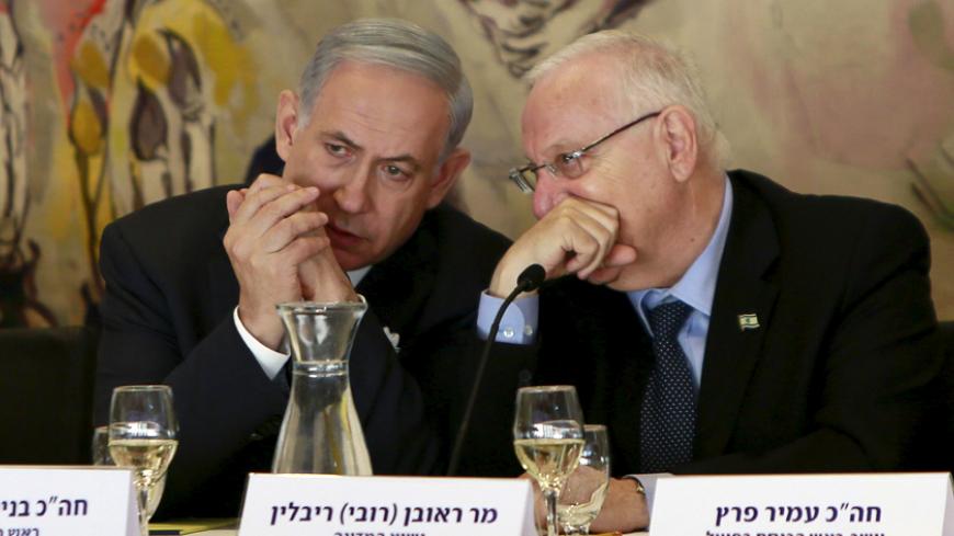 Israel's Prime Minister Benjamin Netanyahu (L) and President Reuven Rivlin converse during an event following the swearing-in ceremony of the 20th Knesset, the new Israeli parliament, in Jerusalem March 31, 2015. Netanyahu said on Tuesday the framework Iranian nuclear agreement being sought by international negotiators will leave Iran with the capability to develop a nuclear weapon in under a year. REUTERS/Gali Tibbon/Pool  - RTR4VMZC