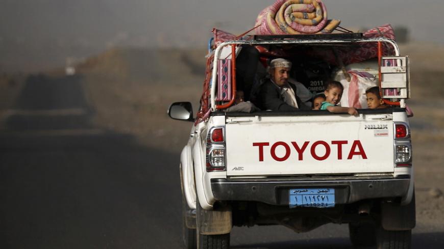 A man and his children ride on the back of a pick-up truck with their luggage as they flee Saudi-led air strikes in Sanaa April 6, 2015. Foreign nationals were on their way out of Yemen on Monday (April 6) as 12 days of strikes by a Saudi-led coalition have failed to halt the advance of the Iran-allied Houthis and triggered a growing humanitarian crisis for residents in central districts now cut off from the mainland. REUTERS/Khaled Abdullah - RTR4W8WJ