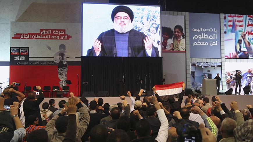 Lebanon's Hezbollah leader Sayyed Hassan Nasrallah greets his Lebanese and Yemeni supporters through a giant screen during a speech against US-Saudi aggression in Yemen, in Beirut's southern suburbs April 17, 2015. REUTERS/Aziz Taher  - RTR4XS93