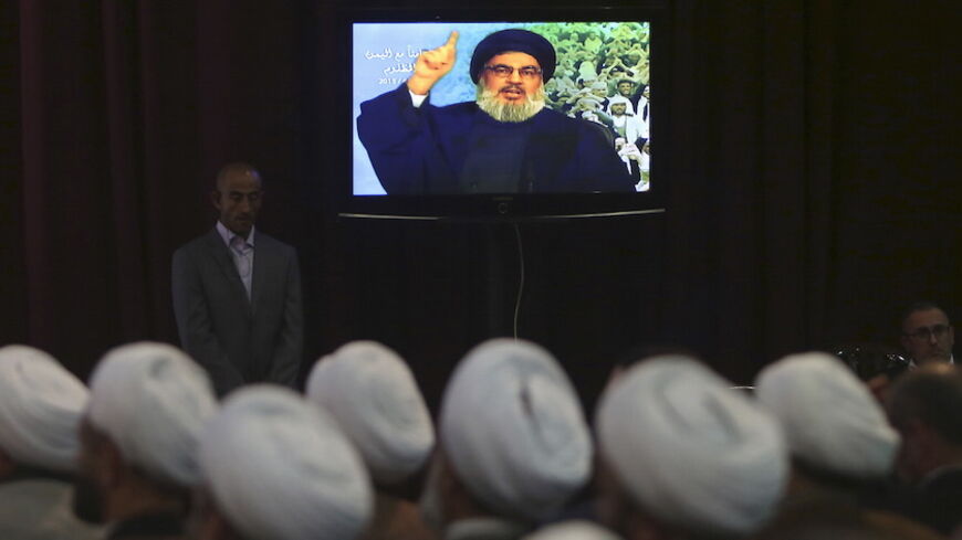 Lebanon's Hezbollah leader Sayyed Hassan Nasrallah talks to his Lebanese and Yemeni supporters through a giant screen during a speech against U.S.-Saudi aggression in Yemen, in Beirut's southern suburbs April 17, 2015. REUTERS/Aziz Taher  - RTR4XSC5