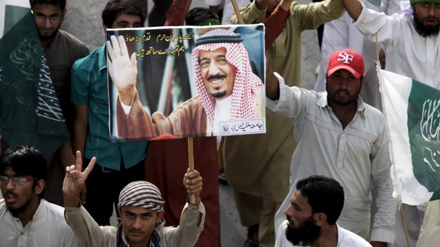 A supporter of the Jamiat Ahle Hadith organization holds a picture of Saudia Arabia's King Salman bin Abdulaziz during a rally in support of Saudi Arabia over its intervention in Yemen, in Lahore April 19, 2015. . REUTERS/Mohsin Raza