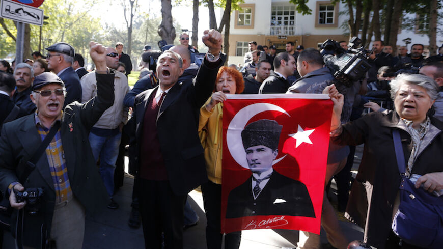 Relatives of detained military officers hold a portrait of Mustafa Kemal Ataturk, founder of modern Turkey, and  shout slogans in front of a courthouse in Ankara October 9, 2013. Turkey's appeals court upheld convictions on Wednesday of top retired military officers for leading a plot to overthrow Prime Minister Tayyip Erdogan's government a decade ago in a case underlining civilian dominance over a once all-powerful army. The court overturned convictions of dozens of less prominent defendants among more th