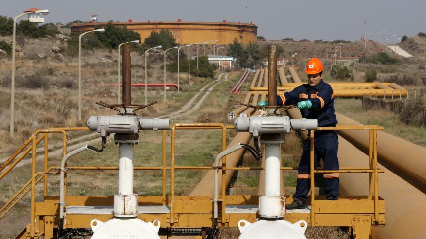 A worker checks the valve gears of pipes linked to oil tanks at Turkey's Mediterranean port of Ceyhan, which is run by state-owned Petroleum Pipeline Corporation (BOTAS), some 70 km (43.5 miles) from Adana February 19, 2014. Crude oil flow through the Kirkuk-Ceyhan pipeline linking Iraq to Turkey restarted on Wednesday at a rate of at a rate of about 300,000-350,000 barrels per day (bpd), a Turkish energy official said. The pipeline, which carries Kirkuk crude to Turkey's Mediterranean port of Ceyhan, was d