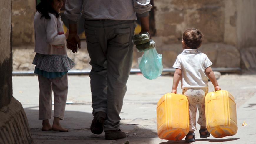 A boy carries jerrycans to fill with water from a faucet amid an acute shortage of clean drinking water in Sanaa April 20, 2015. REUTERS/Mohamed al-Sayaghi - RTX19IVJ