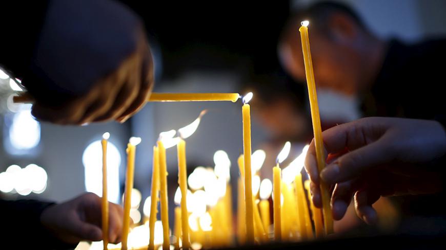 People light candles in memory of the victims of mass killings of Armenians by Ottoman Turks at the main cathedral in Echmiadzin, April 23, 2015. Armenia's president said on Wednesday he was ready to normalize relations with Turkey, two months after he withdrew peace accords from parliament, blaming a Turkish lack of political will to end 100 years of hostility.  REUTERS/David Mdzinarishvili - RTX19YTQ