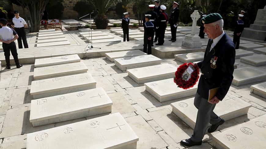 A military veteran walks among gravestones at the Pieta Military Cemetery before a service to mark the 100th anniversary of ANZAC (Australian and New Zealand Army Corps) landings at Galllipoli, in Pieta, Malta, April 25, 2015. The Gallipoli campaign has resonated through generations, which have mourned the thousands of soldiers from the ANZAC cut down by machinegun and artillery fire as they struggled ashore on a narrow beach. The fighting would eventually claim more than 130,000 lives, 87,000 of them on th