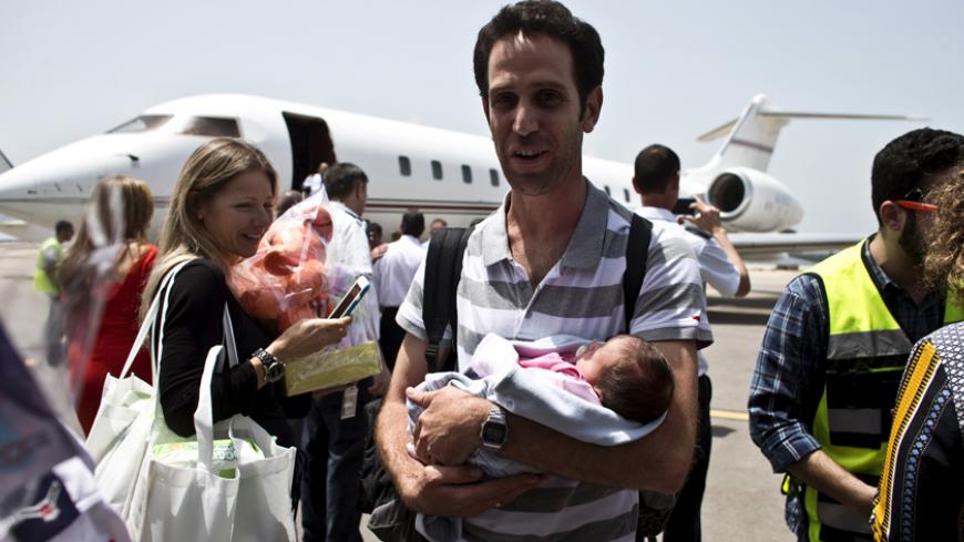 An Israeli man holds his baby, born to a surrogate mother, after being evacuated from Nepal and landing at Sde Dov airport in Tel Aviv, Israel April 27, 2015.  Israel began evacuating infants born to surrogate mothers and their Israeli parents from Nepal on Monday, on the return legs of flights sent to provide earthquake relief. Many Israeli male couples have fathered children with the help of surrogate mothers in Nepal because in Israel the procedure is limited by law to heterosexual partners. REUTERS/Nir 
