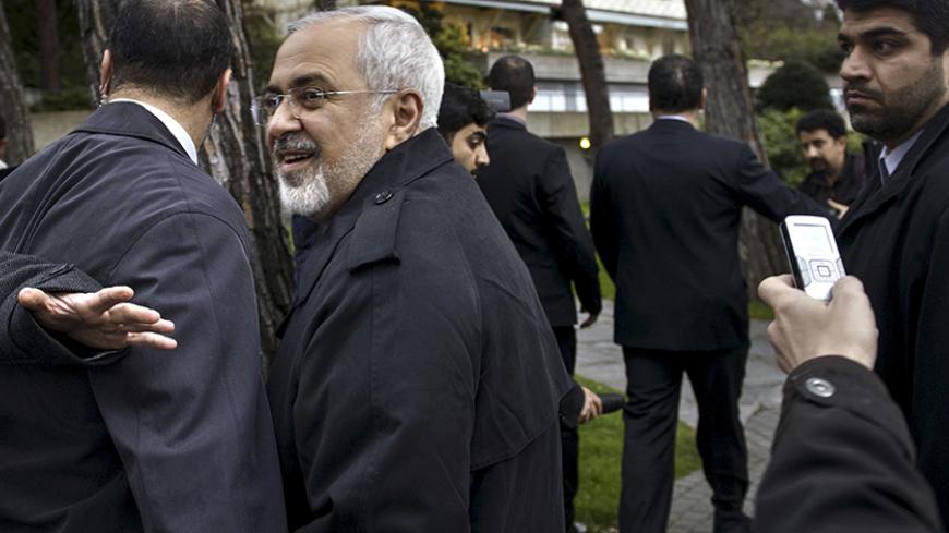 Iranian Foreign Minister Javad Zarif talks to members of the media while walking through a courtyard at the Beau Rivage Palace Hotel during an extended round of talks in Lausanne April 1, 2015. Zarif said on Wednesday that the nuclear talks with the success major powers could succeed if they have political will to resolve Iran's 12-year old nuclear standoff.    REUTERS/Brendan Smialowski/Pool - RTR4VSDR