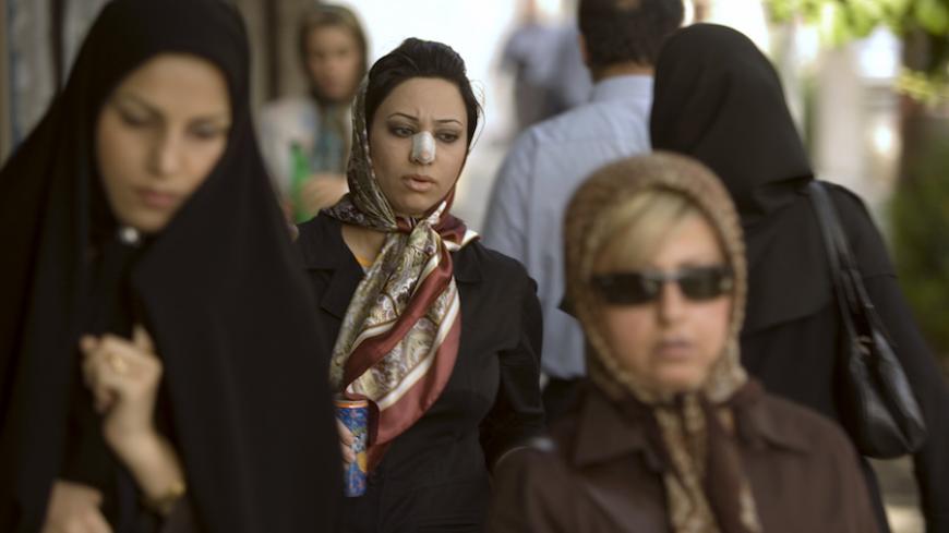 Arezoo Abassi (C) walks along a street in Tehran June 24, 2007, three weeks after undergoing nose surgery.  REUTERS/Caren Firouz  (IRAN) - RTR1R44J