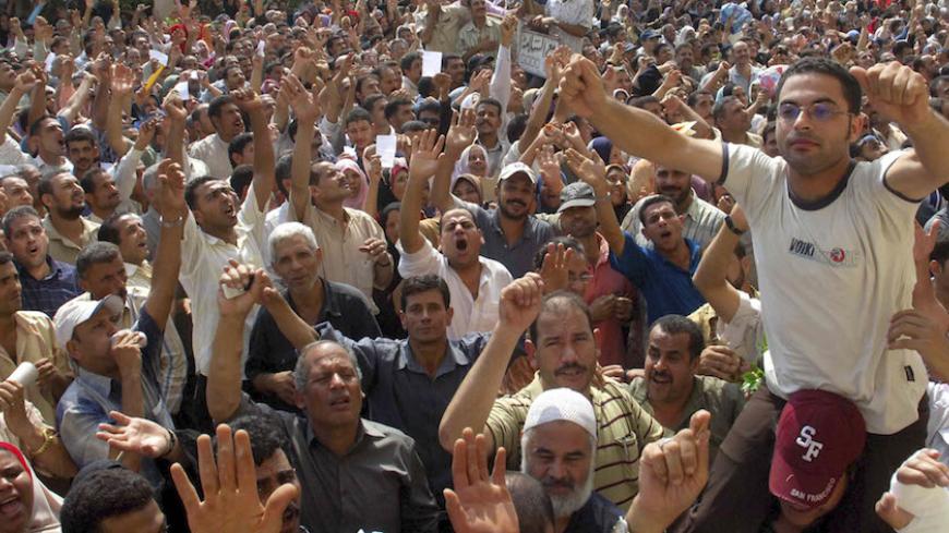 Textile workers stage a strike over pay at Ghazl el-Mahalla factory in Mahalla city, 130km north of Cairo, September 23, 2007.  REUTERS/ Stringer (EGYPT) - RTR1U6E7