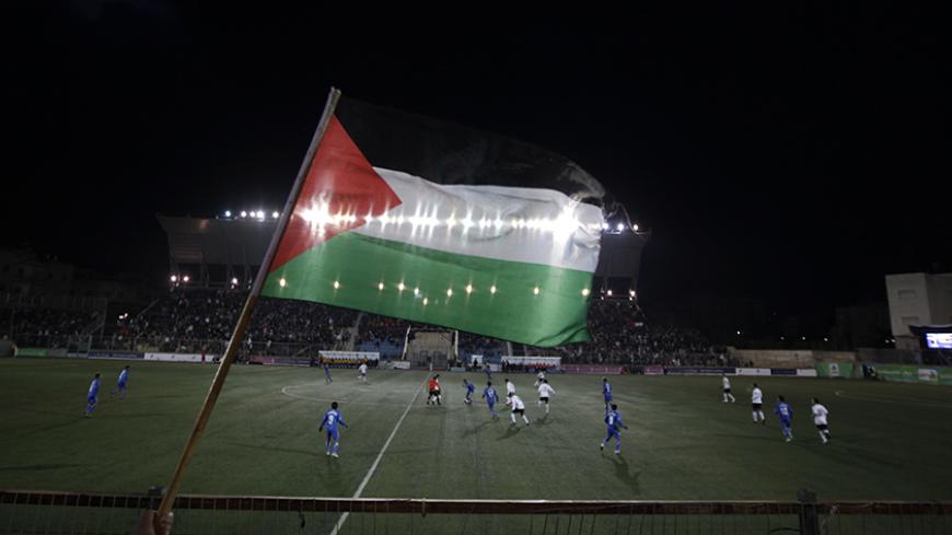 A Palestinian national flag is seen during the Olympic games qualifying match between Palestinian and Thai national soccer teams at a stadium in the West Bank town of A-Ram near Jerusalem March 9, 2011. The match is the first official international fixture to be hosted on Palestinian home soil.  REUTERS/Ammar Awad (WEST BANK - Tags: SPORT SOCCER) - RTR2JOA8