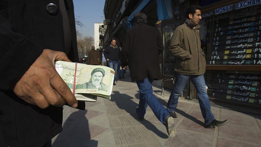 EDITORS' NOTE: Reuters and other foreign media are subject to Iranian restrictions on leaving the office to report, film or take pictures in Tehran.

A money changer holds Iranian rial banknotes as he waits for customers in Tehran's business district January 7, 2012. REUTERS/Raheb Homavandi  (IRAN - Tags: BUSINESS) - RTR2VZCL