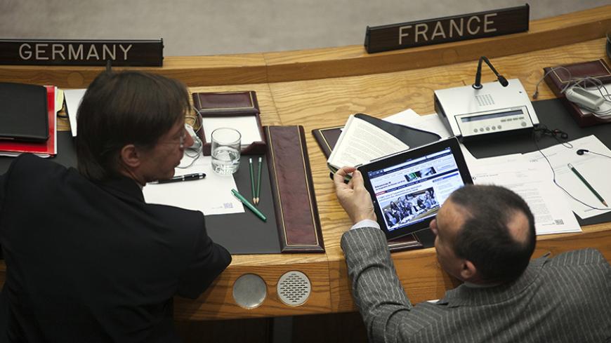 France's ambassador to the U.N. Gerard Araud (R) shows his German counterpart Peter Wittig the French newspaper Le Monde's website on his iPad during a Security Council meeting at the United Nations in New York April 14, 2012. The U.N. Security Council on Saturday unanimously authorized the deployment of up to 30 unarmed observers to Syria to monitor the country's fragile ceasefire. Russia and China joined the other 13 council members and voted in favor of the Western-Arab draft resolution. REUTERS/Allison 
