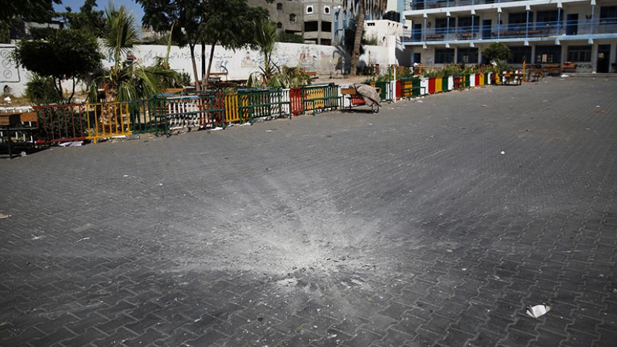 A crater marks the centre of a courtyard at a United Nations-run school sheltering Palestinians displaced by an Israeli ground offensive, that police said was hit by an Israeli shell, in Beit Hanoun in the northern Gaza Strip July 24, 2014. At least 15 people were killed and many wounded on Thursday when Israeli forces shelled a U.N.-run school sheltering Palestinian refugees in northern Gaza, said a spokesman for the Gaza health ministry, Ashraf al-Qidra. Chris Gunness, spokesman for the main U.N. agency i