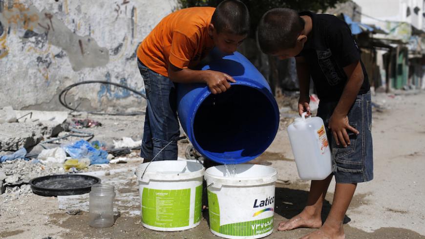 Palestinians youths who fled their neighbourhood during the Israeli offensive, fetch water from a  container after returning to their damaged home in the Beit Hanoun area during a 72-hour ceasefire, Gaza City, August 11, 2014. Israeli negotiators arrived in Cairo on Monday to meet with Egyptian mediators who are holding talks on ending a month-old Gaza war between Israel and Palestinian militants, sources at the airport and foreign ministry said. The two sides agreed on Sunday to a new 72-hour ceasefire to 