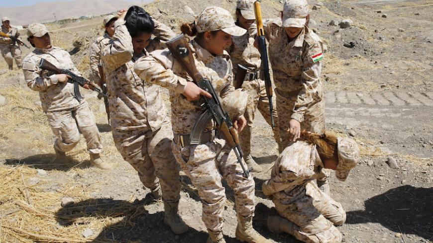Kurdish Peshmerga female fighters practise the procedure of dealing with prisoners during combat skills training before being deployed to fight Islamic State militants, at their military camp in Sulaimaniya, northern Iraq September 18, 2014. REUTERS/Ahmed Jadallah (IRAQ - Tags: CIVIL UNREST CONFLICT MILITARY TPX IMAGES OF THE DAY) - RTR46QER