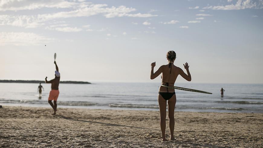 A woman spins a hula hoop around her waist on a beach in Tel Aviv December 4, 2014.Unusually hot weather has hit Israel in the last few days with temperatures reaching 26 degrees Celsius (79 degrees Fahrenheit) at mid-day.  
REUTERS/Baz Ratner (ISRAEL - Tags: ENVIRONMENT SOCIETY) - RTR4GPUT