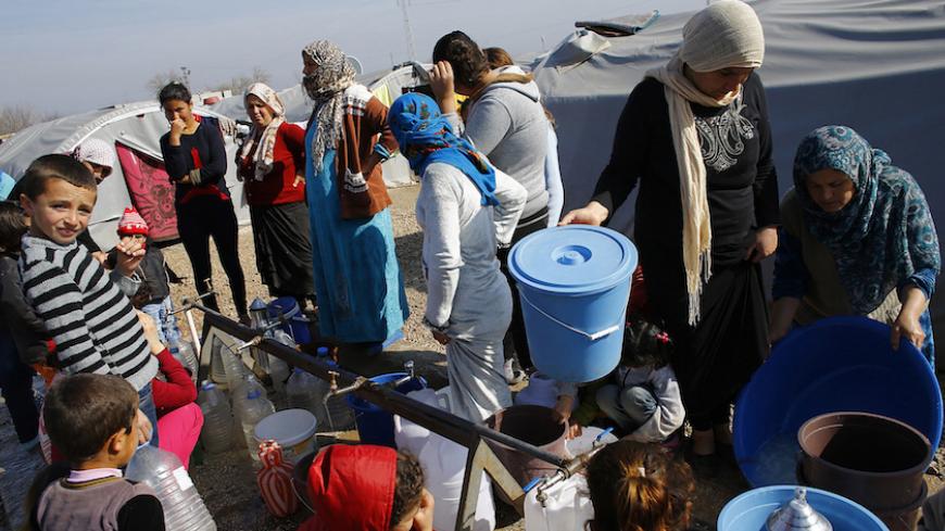Kurdish refugees from the Syrian town of Kobani wait to fill their jerrycans around a clean water source at a refugee camp in the border town of Suruc, Sanliurfa province February 1, 2015. REUTERS/Umit Bektas (TURKEY - Tags: POLITICS CIVIL UNREST CONFLICT) - RTR4NRVB