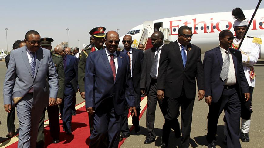 Sudanese President Omar Hassan al-Bashir (C) welcomes Ethiopian Prime Minister Hailemariam Desalegn (L) at Khartoum Airport, ahead of their signing of an Agreement on Declaration of Principles between Sudan, Egypt and Ethiopia on the Grand Ethiopian Renaissance Dam Project,  in Khartoum March 23, 2015. The leaders of Egypt, Ethiopia and Sudan signed a cooperation deal on Monday over a giant Ethiopian hydroelectric dam on a tributary of the river Nile, in a bid to ease tensions over regional water supplies. 