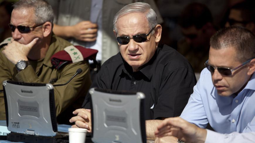 Israeli Prime Minister Benjamin Netanyahu (C) sits next to armed forces chief Major-General Benny Gantz (L) and Gilad Erdan, minister of communications and home front protection, during a drill simulating a chemical rocket attack in Jerusalem May 29, 2013. Israel continued on Wednesday with its annual home front defence exercise, launched on Monday, preparing soldiers and civilians for missile attacks. REUTERS/Abir Sultan/Pool (JERUSALEM - Tags: POLITICS MILITARY) - RTX104PX