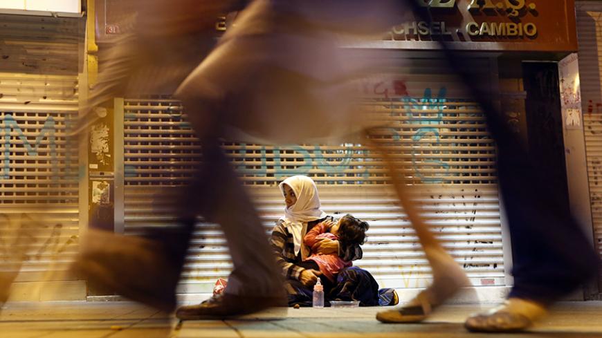 A woman holds a child as she begs for money near Taksim Square in Istanbul June 19, 2013.  REUTERS/Marko Djurica (TURKEY - Tags: SOCIETY POVERTY TPX IMAGES OF THE DAY) - RTX10SP4
