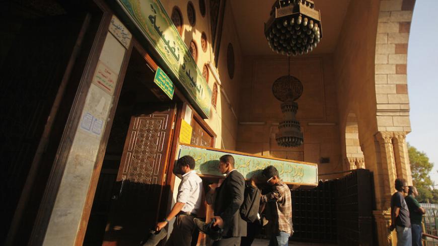 Egyptians carry the coffin of a Shi'ite victim, who was killed in sectarian violence, before funeral prayers in El Sayeda Nafisa Mosque in Cairo, June 24, 2013. Egypt's president, accused of fuelling sectarian hatred, promised swift justice on Monday for a deadly attack on minority Shi'ites as he tried to quell broader factional fighting to avoid a threatened military intervention.  REUTERS/Amr Abdallah Dalsh  (EGYPT - Tags: POLITICS CIVIL UNREST RELIGION) - RTX10ZDR