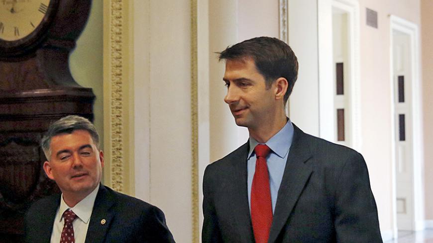 Senator Tom Cotton (R-AR) (R) walks next to an unidentified person as he goes to the Senate floor for a cloture vote, on Capitol Hill in Washington May 7, 2015. The U.S. Senate voted overwhelmingly on Thursday to pass a bill giving Congress the right to review, and potentially reject, an international nuclear agreement with Iran. REUTERS/Gary Cameron

 - RTX1C04S