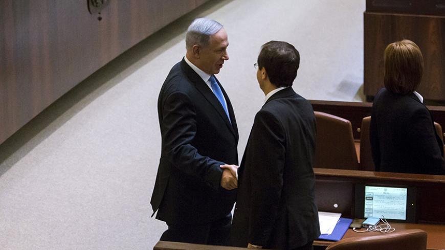 Israeli Prime Minister Benjamin Netanyahu (L) shakes hands with Isaac Herzog, co-leader of the Zionist Union party after he was sworn to office in the Knesset, the Israeli parliament, following the mid-March general elections, in Jerusalem May 14, 2015. Netanyahu's new rightist coalition government, hobbled from the outset by its razor-thin parliamentary majority, was sworn in late on Thursday amid wrangling within his Likud party over cabinet posts. REUETRS/Jim Hollander/Pool - RTX1D0Z3