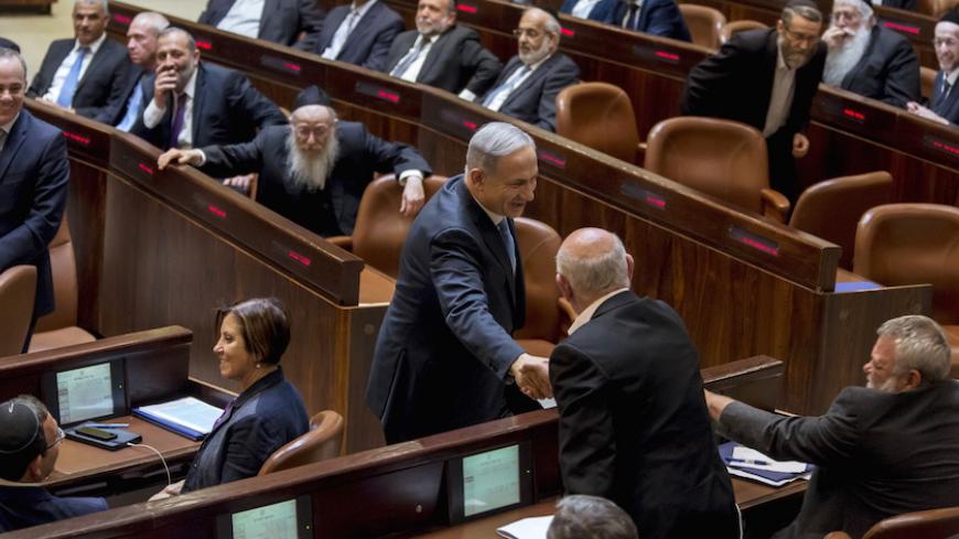 Israeli Prime Minister Benjamin Netanyahu (C) shakes hands with members of the opposition after he was sworn-in as Prime Minister for the fourth time, to lead the 34th Israeli government, at the Knesset, the Israeli parliament, in Jerusalem May 14, 2015. Netanyahu's new rightist coalition government, hobbled from the outset by its razor-thin parliamentary majority, was sworn in late on Thursday amid wrangling within his Likud party over cabinet posts. Picture taken May 14, 2015. REUETRS/Jim Hollander/Pool -