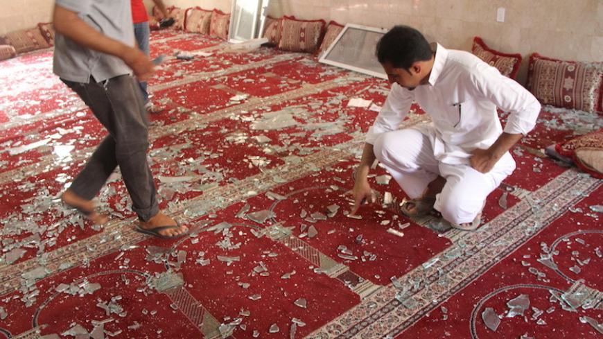 People examine the debris after a suicide bomb attack at the Imam Ali mosque in the village of al-Qadeeh in the eastern province of Gatif, Saudi Arabia, May 22, 2015. A suicide bomber killed 21 worshippers during Friday prayers in the packed Shi'ite mosque in eastern Saudi Arabia, residents and the health minister said, in an attack claimed by the Islamic State militant group. REUTERS/Stringer - RTX1E5SV