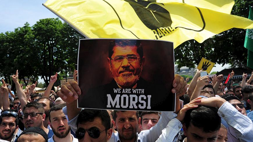 Pro-Islamist demonstrators hold a poster of former Egyptian President Mohamed Mursi during a rally in support of him in front of the Haghia Sophia museum at Sultanahmet square in Istanbul, Turkey, May 24, 2015. REUTERS/Yagiz Karahan TPX IMAGES OF THE DAY      - RTX1ECGI