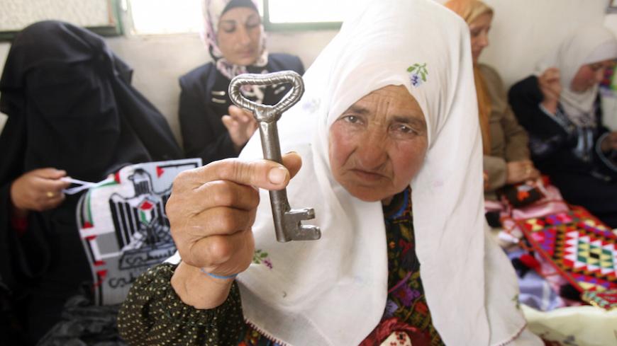 A Palestinian woman holds a key, symbolising the keys to houses left by Palestinians in 1948, near the West Bank city of Hebron May 16, 2009. On May 15 Palestinians marked "Nakba", or "Catastrophe", to commemorate the time when hundreds of thousands of Palestinians were expelled or fled from their homes in the war that led to the founding of Israel in 1948. REUTERS/Nayef Hashlamoun (WEST BANK POLITICS) - RTXHR8H