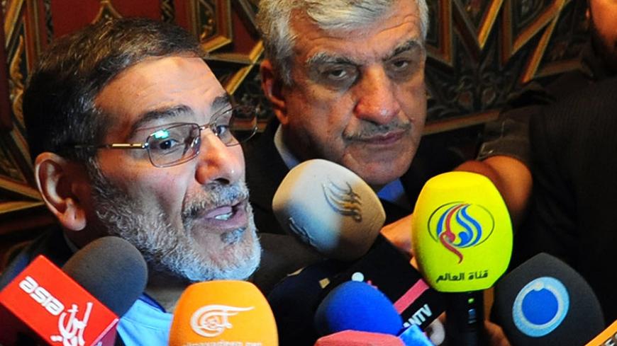 Iranian secretary of the Supreme National Security Council, Ali Shamkhani (L) speaks to reporters at the Damascus airport on September 30, 2014. AFP PHOTO/ STR        (Photo credit should read STR/AFP/Getty Images)