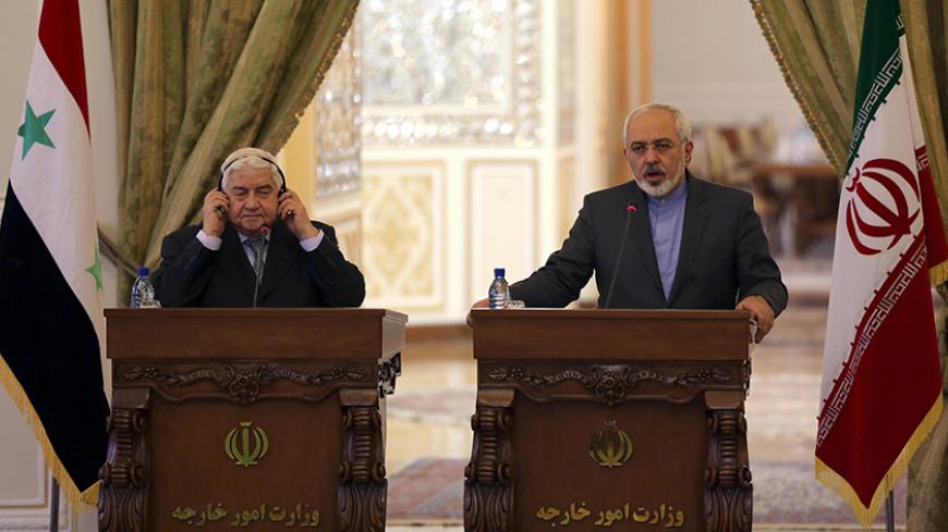 Iranian Foreign Minister Mohammad Javad Zarif (R) holds a press conference with his Syrian counterpart Walid Muallem in Tehran on December 8, 2014, ahead of a conference with their Iraqi counterpart on combating extremism. Iran is the main regional ally of Syrian President Bashar al-Assad, and Tehran has acknowledged sending military advisers to assist his forces in their fight against armed rebels and jihadist militants. AFP PHOTO/ ATTA KENARE        (Photo credit should read ATTA KENARE/AFP/Getty Images)
