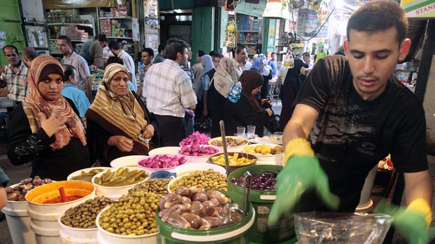 A Palestinian vendor sells pickles in a market as Muslims prepare for the upcoming holy month of Ramadan, in Gaza City August 20, 2009. Muslims around the world abstain from eating, drinking and conducting sexual relations from sunrise to sunset during Ramadan, the holiest month in the Islamic calendar. REUTERS/Mohammed Salem (GAZA RELIGION) - RTR26XC6