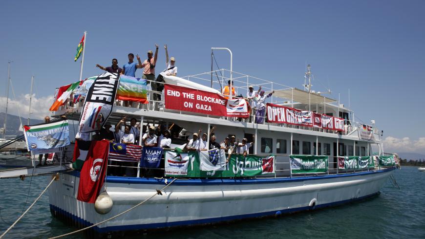 Activists gesture from the "Stefano Chiarini" ship, which is part of the "Freedom Flotilla II",  during a demonstration against the Greek authorities' ban on Gaza-bound ships on the Greek island of Corfu July 2, 2011. Greek authorities said on Friday that ships destined for Gaza -- which involves transit through international waters -- were prohibited from leaving Greek ports.   REUTERS/Marko Djurica (GREECE - Tags: POLITICS) - RTR2ODFT