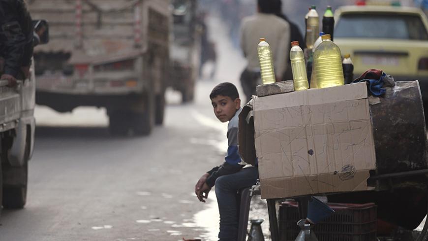A boy sells fuel along a street in Aleppo February 27, 2013. REUTERS/ Giath Taha (SYRIA - Tags: POLITICS CIVIL UNREST SOCIETY ENERGY CONFLICT) - RTR3ED4K