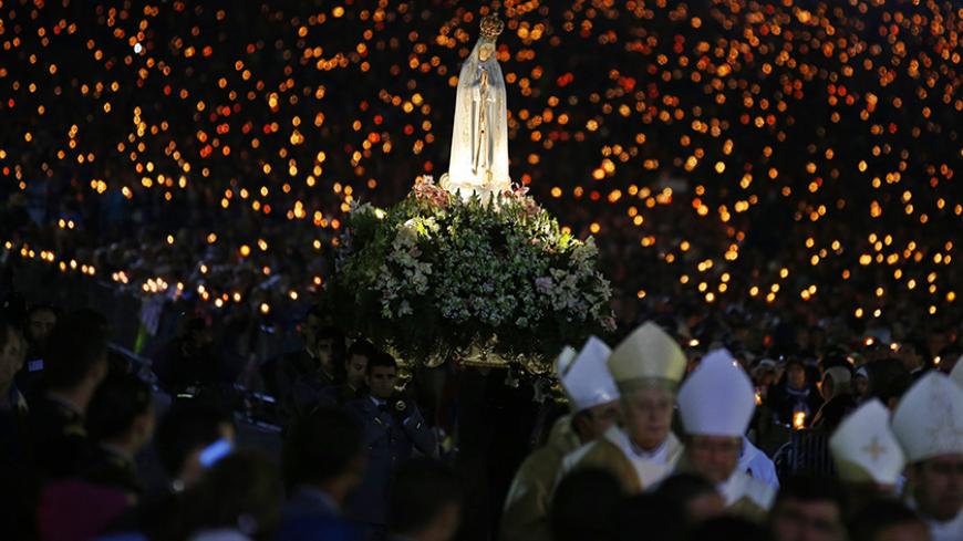 A statue of the Holy Virgin Mary of Fatima is carried during a candlelight vigil at the Fatima holy shrine in central Portugal  May 12, 2014. Thousands of pilgrims are on their way to the Fatima Shrine to attend the 97th anniversary celebrations of the first appearance of the Virgin Mary to three shepherd children in 1917.  REUTERS/Rafael Marchante (PORTUGAL - Tags: ANNIVERSARY SOCIETY RELIGION) - RTR3OV1C