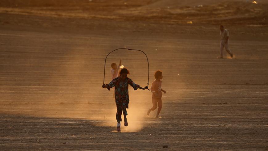 Children, who fled from the violence in Mosul, play during sunset inside the Khazer refugee camp on the outskirts of Arbil, in Iraq's Kurdistan region, June 27, 2014. Grand Ayatollah Ali Sistani, the most influential Shi'ite cleric in Iraq, called on the country's leaders on Friday to choose a prime minister within the next four days, a dramatic political intervention that could hasten the end of Nuri al-Maliki's eight year rule. REUTERS/Ahmed Jadallah (IRAQ - Tags: CIVIL UNREST POLITICS SOCIETY TPX IMAGES 