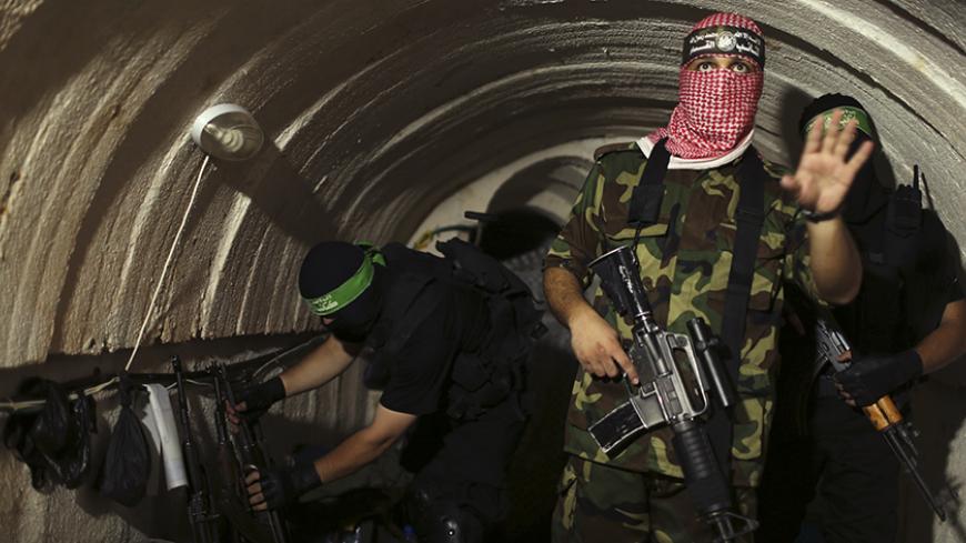 A Palestinian fighter from the Izz el-Deen al-Qassam Brigades, the armed wing of the Hamas movement, gestures inside an underground tunnel in Gaza August 18, 2014. A rare tour that Hamas granted to a Reuters reporter, photographer and cameraman appeared to be an attempt to dispute Israel's claim that it had demolished all of the Islamist group's border infiltration tunnels in the Gaza war. Picture taken August 18, 2014. REUTERS/Mohammed Salem (GAZA - Tags: POLITICS CONFLICT TPX IMAGES OF THE DAY) - RTR42YJW