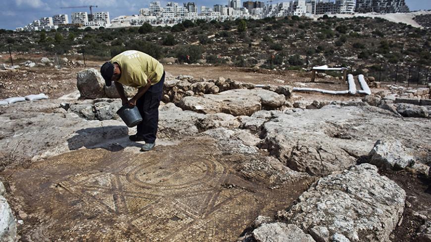 A worker for the Israel Antiquities Authority (IAA) works at an excavation site where a compound containing an oil press, a wine press and mosaics was exposed near the Israeli town of Beit Shemesh September 18, 2014. The compound, dating to the Byzantine period, was very likely a monastery, Excavation Director of the IAA archaeologist Irene Zilberbod said in a statement on Thursday. REUTERS/Nir Elias (ISRAEL - Tags: SOCIETY) - RTR46QDX