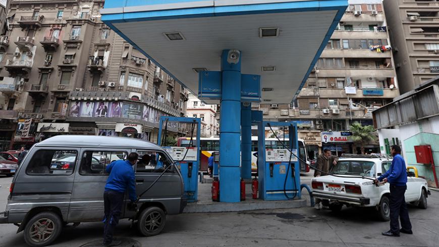 Vehicles are seen being filled up with fuel by employees at a CO-OP petrol station in Cairo, January 13, 2015. Picture taken January 13, 2015.   REUTERS/Mohamed Abd El Ghany (EGYPT  - Tags: TRANSPORT BUSINESS COMMODITIES ENERGY SOCIETY)   - RTR4OZSX