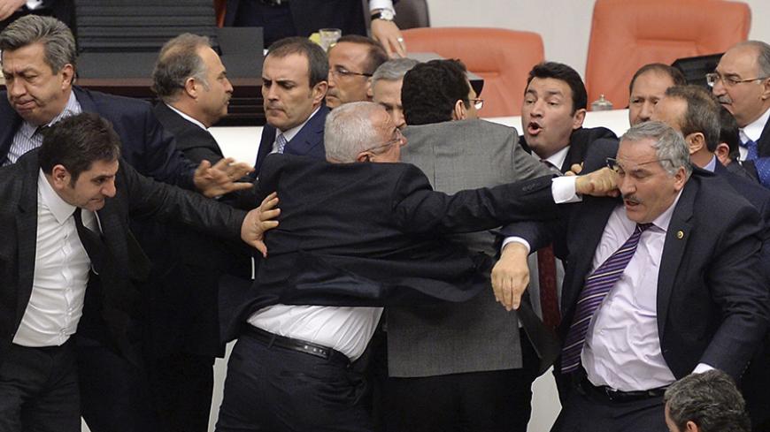 Main opposition Republican People's Party (CHP) and ruling AK Party (R) lawmakers scuffle during a debate on a legislation to boost police powers, at the Turkish Parliament in Ankara late February 19, 2015. The legislation, which would bolster the powers of the authorities to control protests, has been widely condemned by the opposition, who accuse the AKP of trying to create a police state in the NATO member nation. REUTERS/Stringer (TURKEY - Tags: CRIME LAW POLITICS TPX IMAGES OF THE DAY) - RTR4QBIU