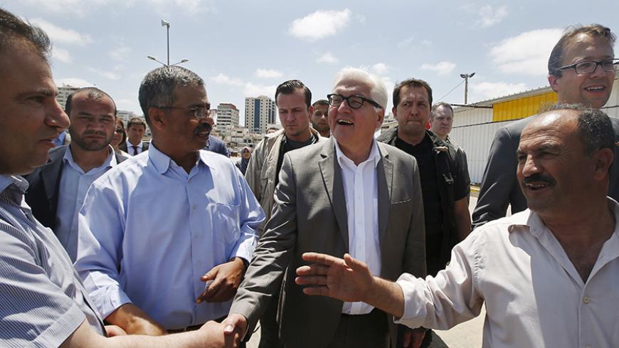 Germany's Foreign Minister Frank-Walter Steinmeier (C) shakes hands with a Palestinian man during his visit to the Seaport of Gaza City June 1, 2015.  REUTERS/Mohammed Salem


 - RTR4YB2G