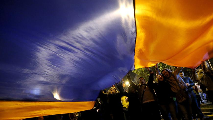 Demonstrators carry the Armenian flag during a torch-bearing march marking the centenary of the mass killing of Armenians by Ottoman Turks in Yerevan, Armenia, April 24, 2015. Armenia marked the centenary on Friday of a mass killing of Armenians by Ottoman Turks with a simple flower-laying ceremony attended by foreign leaders as Germany became the latest country to respond to its calls for recognition that it was genocide. Turkey denies the killing of up to 1.5 million Armenians in what is now Turkey in 191