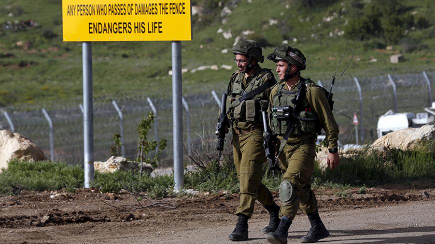 Israeli soldiers walk near the frontier with Syria near Majdel Shams in the Golan Heights April 27, 2015. An Israeli air strike killed four militants on Sunday as they placed an explosive on a fence near Israel's frontier with Syria in the annexed Golan Heights, an Israeli military source said. REUTERS/Baz Ratner  - RTX1AIJ3