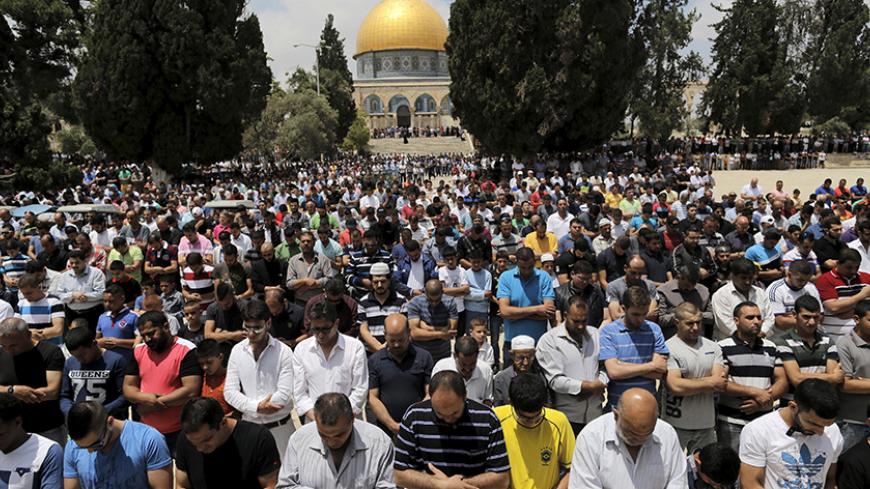 Palestinian men take part in Friday prayers as the Dome of the Rock on the compound known to Muslims as the Noble Sanctuary and to Jews as Temple Mount in Jerusalem's Old City is seen in the background May 29, 2015. Picture taken May 29, 2015.  To match Special Report ISRAEL-JERUSALEM/DOME   REUTERS/Ammar Awad  
 - RTX1F1V6
