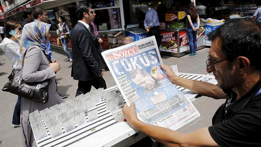 A lottery ticket vendor reads a Turkish newspaper published with an headline reads "downfall" and a portrait of Turkey's President Tayyip Erdogan in Ankara, Turkey, June 8, 2015. Erdogan will meet Prime Minister Ahmet Davutoglu on Monday to discuss Sunday's election results during which the ruling AK Party lost its parliamentary majority. The elections have ushered in the biggest period of political uncertainty in Turkey since AK Party swept to power 13 years ago. REUTERS/Umit Bektas  - RTX1FM5M