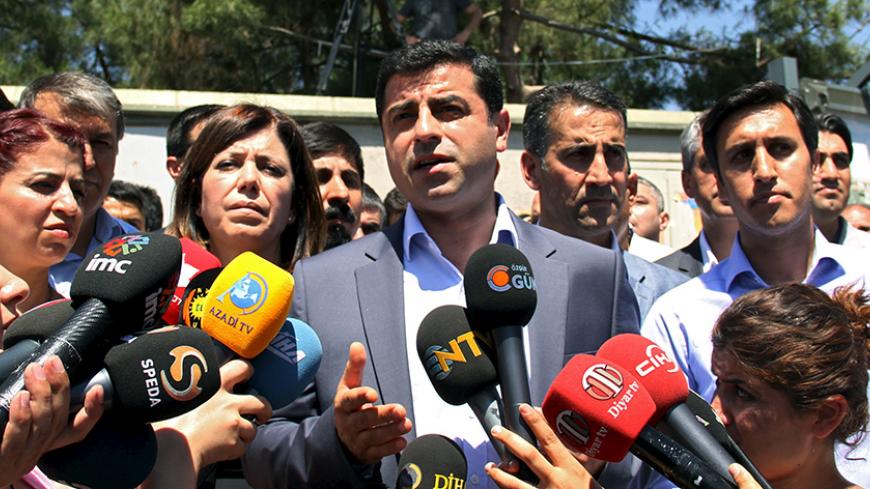 Selahattin Demirtas (C), co-leader of pro-Kurdish Peoples' Democratic Party (HDP), talks to the media in Diyarbakir, Turkey, June 12, 2015. The leader of Turkey's pro-Kurdish opposition party on Friday accused figures within the state of links to violence in the largely Kurdish southeastern province of Diyarbakir this week, which left four dead. The violence between different Kurdish factions came days after a parliamentary election which saw the ruling AK Party lose its majority, casting doubt over stalled